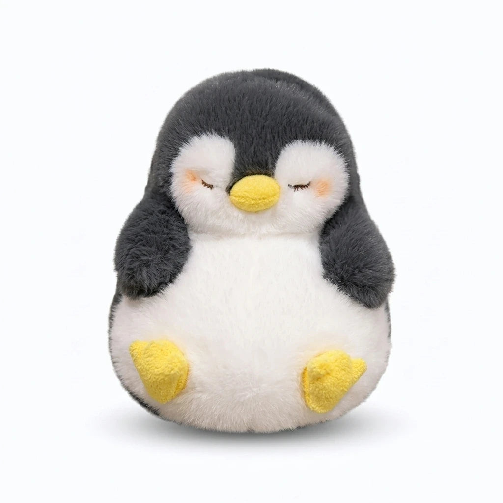 Pingouin doudou gris clair posé sur un canapé comme coussin de détente