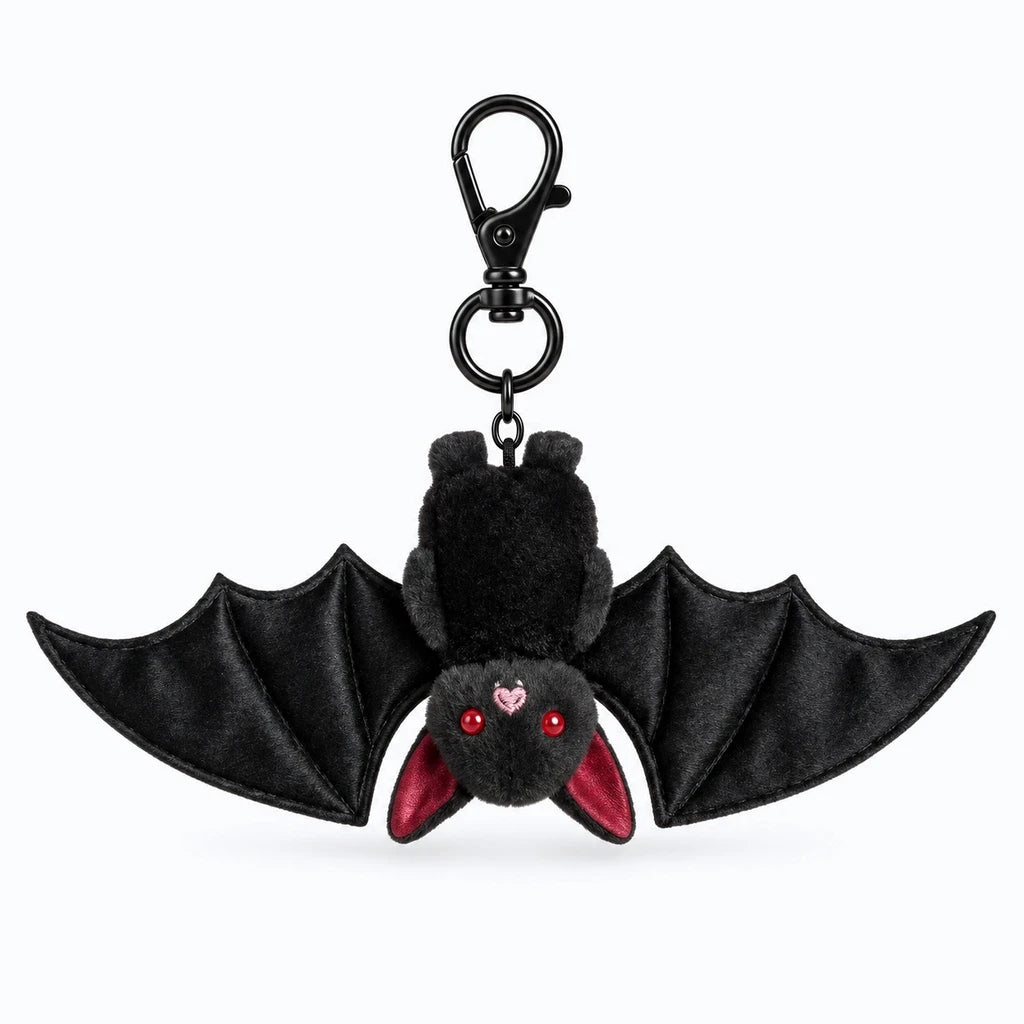 Porte clé doudou noir pelucheux accroché à un sac à dos