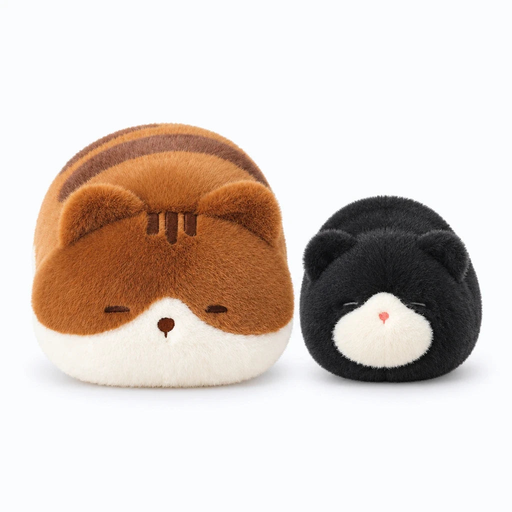 Peluche de chat noir posée sur un lit comme oreiller de sommeil confortable