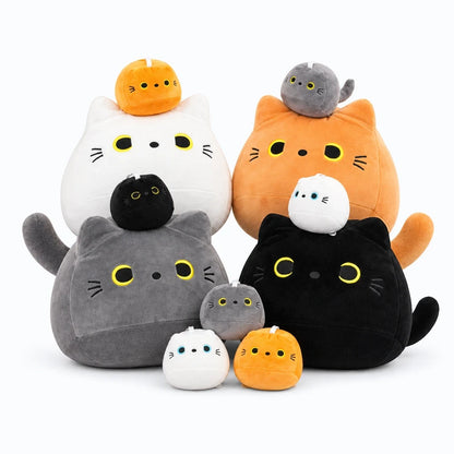Chat en peluche noir posé sur un lit comme oreiller décoratif