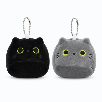 Petit chaton en peluche gris assis à côté de la maman chat noir